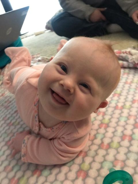 Baby plays on floor and smiles