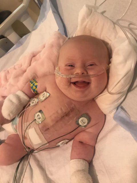 Baby in hospital with tubes while smiling