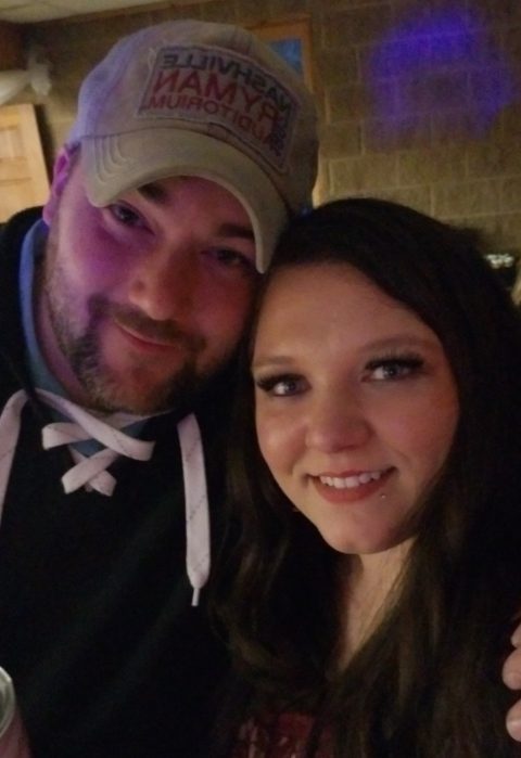 Man in cap poses with woman