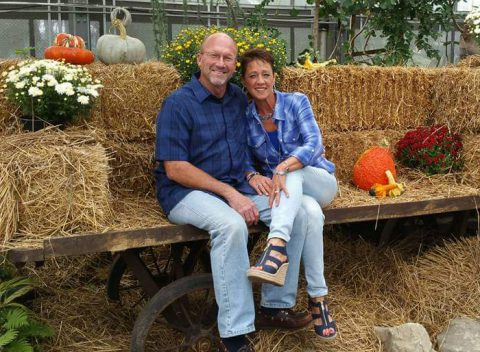 Kevin B. and his wife, Lisa, sit on a trailer with hay bales and fall decorations